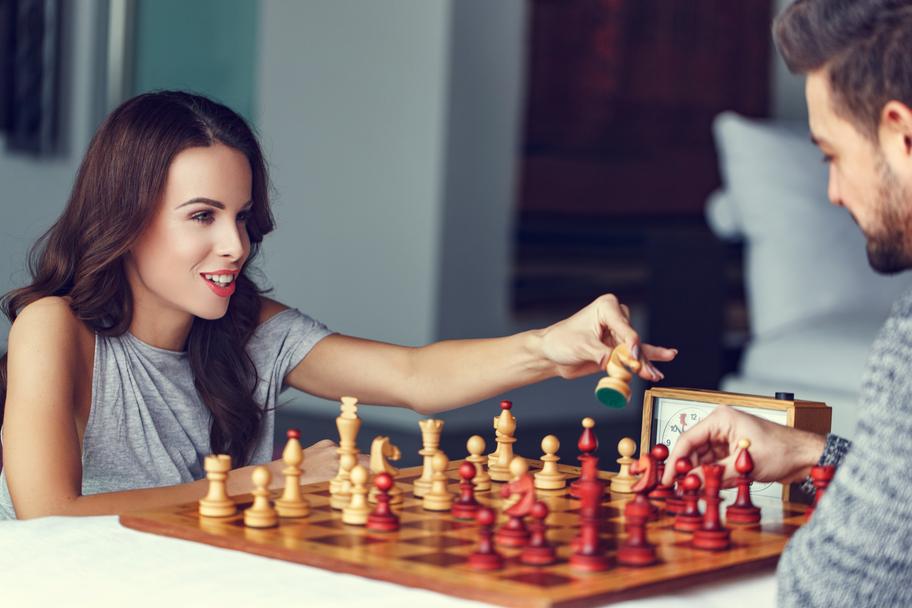 young couple playing chess indoor